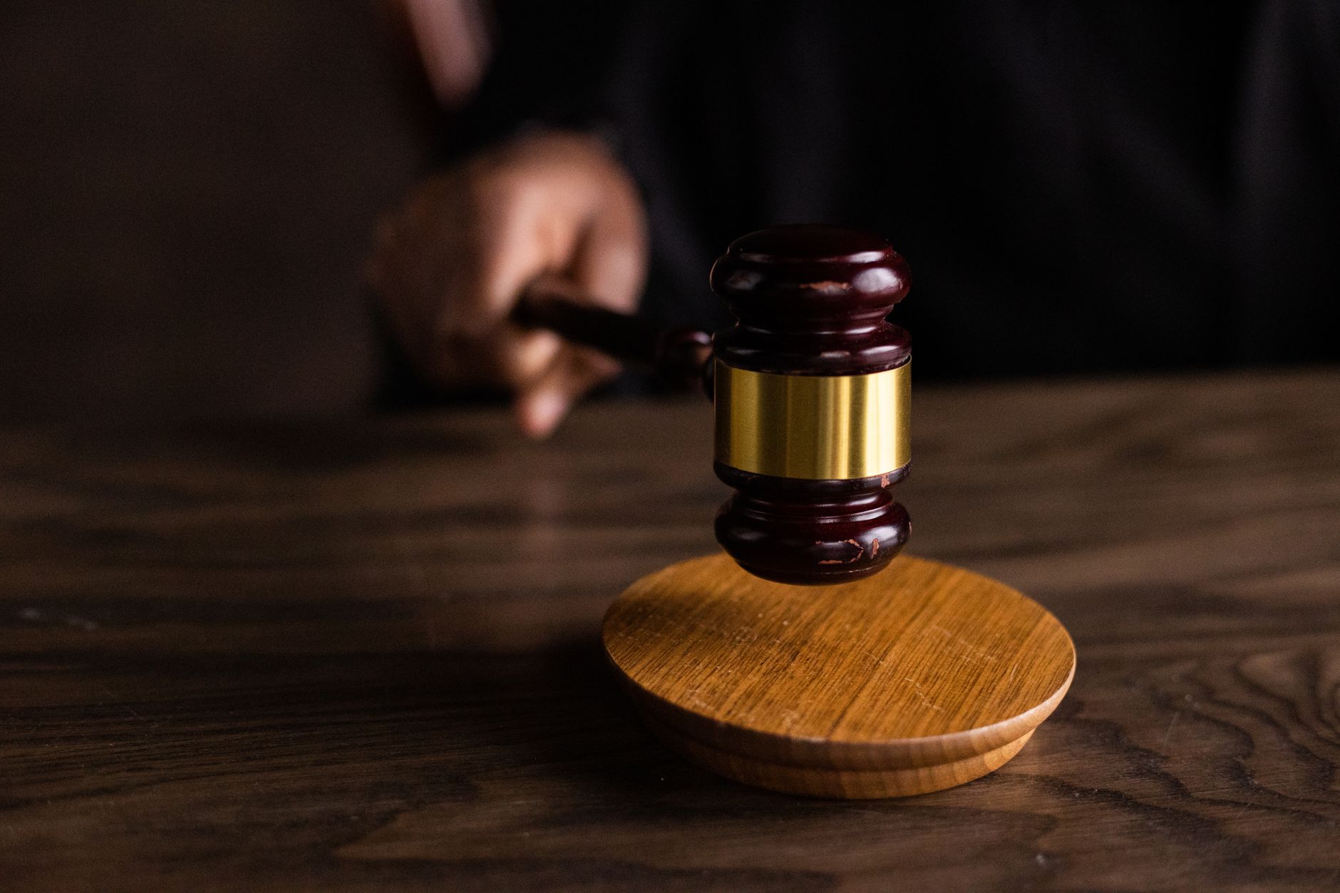 A wooden gavel resting on a courtroom table