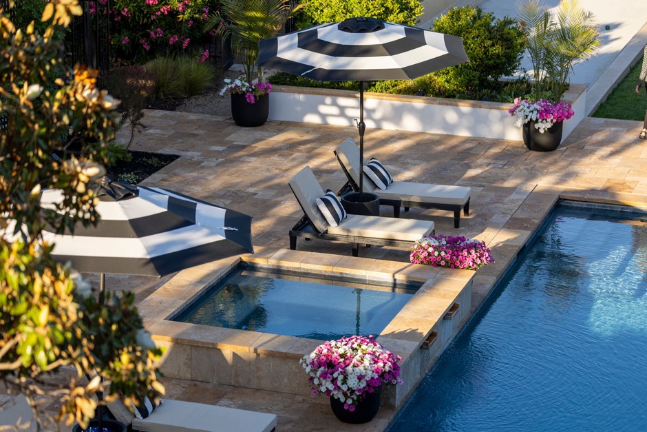 Elegant poolside landscape design with lounge chairs at a luxury estate