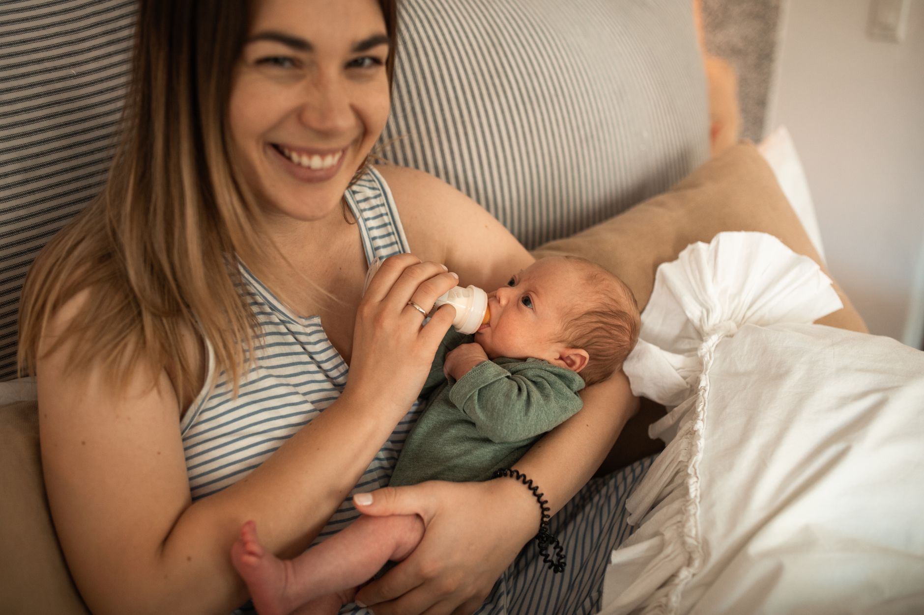 A mother gently holding her newborn baby