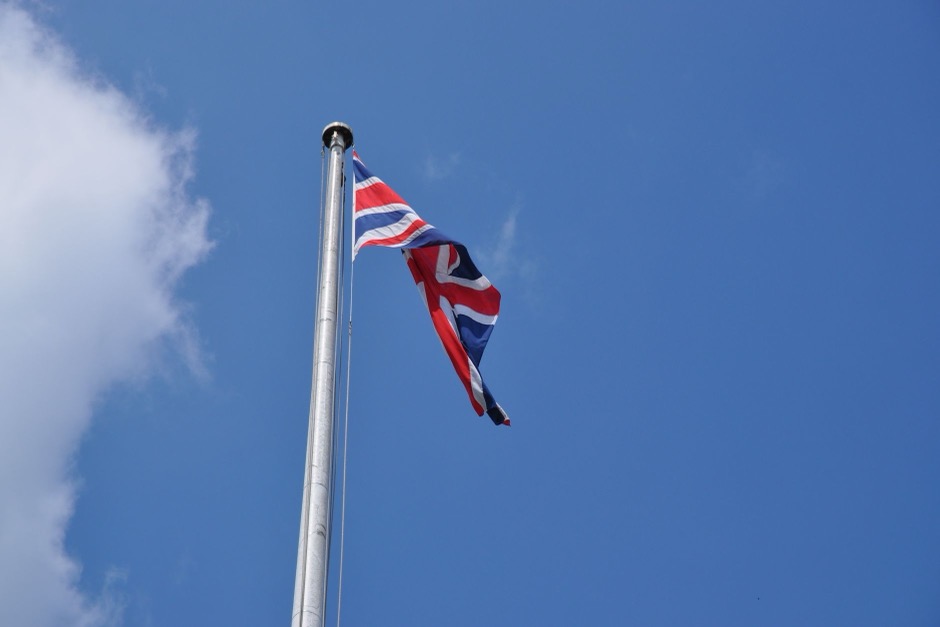 Union Jack flag waving against a clear blue sky
