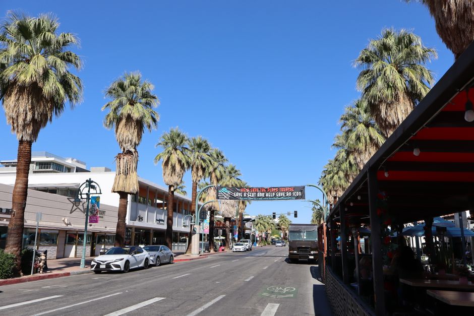 Palm-lined downtown Palm Springs street under a clear desert sky
