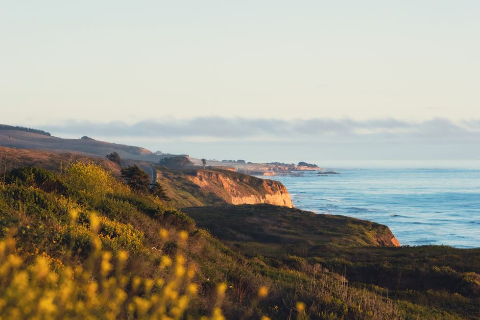 California coastline cliffs meeting the Pacific Ocean at golden hour