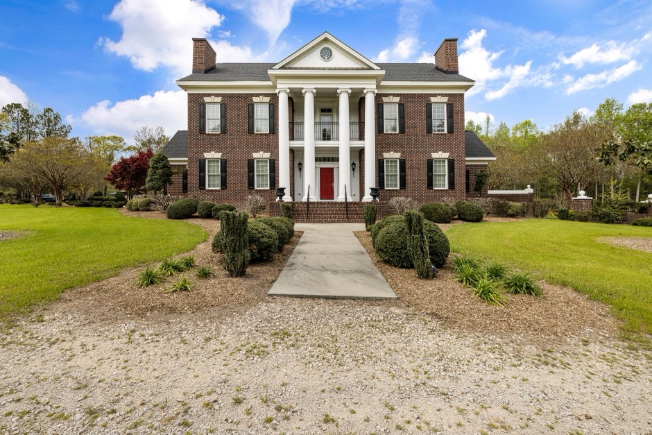 Stately brick colonial estate home with mature trees, typical of Preston Hollow